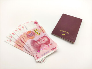 Stack of Chinese yuan's banknotes and passport on a white background close up