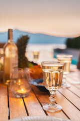 Romantic dinner table at sunset with sea view. Wine concept. Mediterranean restaurant table