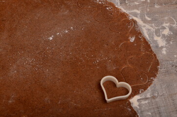 Flat rolled Raw dough for cooking Christmas cookies with ginger heart and other shapes, top view,...