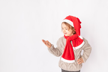 a little girl in a Santa hat on a white background holds her hand for space for text