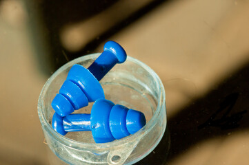 top view, close distance of two, blue swimming ear plugs and plastic case