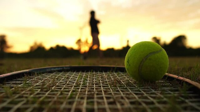 Footage Slow Motion: Tennis ball on a tennis racket with a tennis player practicing at sunset