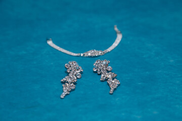 Diamond necklace and earrings on blue background