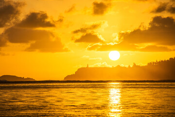 Naklejka premium Sunrise at Anini Beach in Kauai with silhouette of Kilauea Point and lighthouse