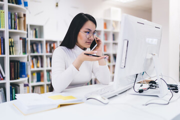 Asian businesswoman speaking on smartphone in office