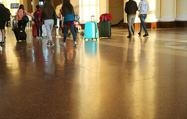 Group of people with luggage walking in arrival hall of a railway station for the concept of TRAVEL