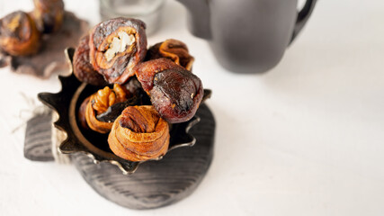 Syrian sweets are served on the table. A mixture of Arabic sweets and dates of hastac. Dried fruit rolls stuffed with walnuts close-up. Selective focus. Small depth of field.