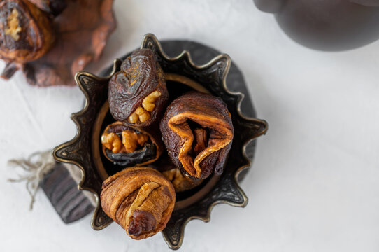 Syrian sweets are served on the table. A mixture of Arabic sweets and dates of hastac. Dried fruit rolls stuffed with walnuts close-up. Selective focus. Small depth of field