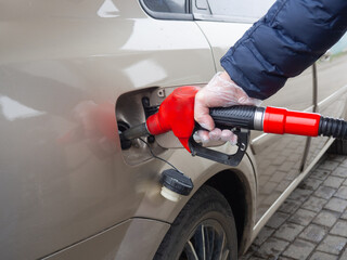 a man refuels a car with a disposable glove. safety from germs.prevention from coronavirus