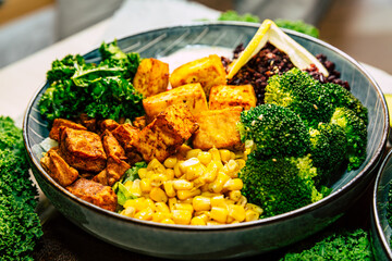 Healthy buddha bowl vegan lunch with tofu, , spinach, avocado, broccoli, beans with seeds