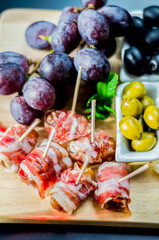 Delicious figs wrapped in bacon served with blue cheese, grapes and olives