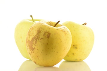 Three fresh yellow apples, close-up, isolated on white.