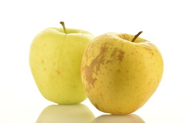 Two fresh yellow apples, close-up, isolated on white.
