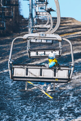 woman going up by chairlift to ski