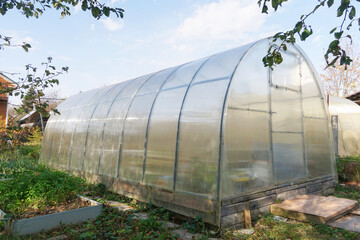 Frame polycarbonate greenhouse in the garden for many varieties of vegetables: tomatoes, cucumbers, paprika, etc.