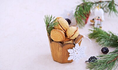 Shortbread cookies Nuts stuffed with chocolate paste or condensed milk in a wooden jar in a Christmas and New Year style on a light concrete background. Cookie recipes.