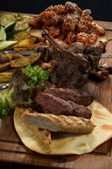 different types of cooked meat and dishes on a black background