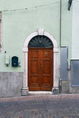 Italian retro wood style front door, the main entrance. Element of the classic Italian facade and architecture