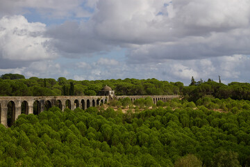 Fototapeta na wymiar Impressive 17th century built Aqueduct for transporting of water from Pegoes springs to Convent of Christ, Tomar, Portugal. Surrounded by lush green forests. Influenced- Roman and Muslim architecture.