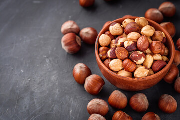 fresh natural hazelnuts on a dark stone background