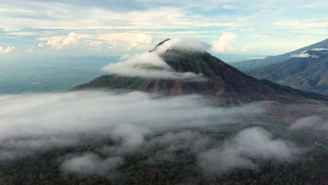 Stunning aerial view of a beautiful mountain range surrounded by clouds during sunrise. Ijen Volcano complex. The Ijen volcano complex is a group of composite volcanoes located in East Java, Indonesia