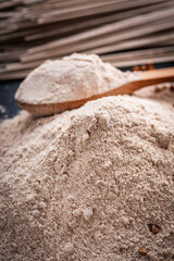 Fototapeta na wymiar fresh natural buckwheat flour on a dark stone background culinary concept