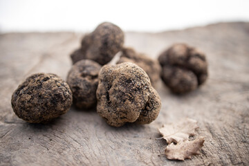 Black truffles on a wood surface.
