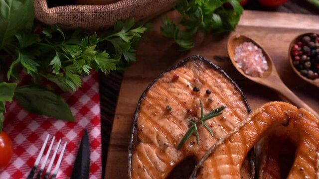 salmon fish steak with herbs and vegetables on wooden background