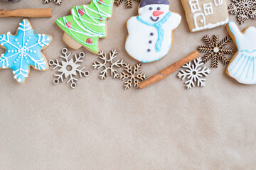 Gingerbread painted colored gingerbread cookies and spices and snowflakes on a craft background close-up. Christmas celebration concept. New Year's food. Copy space