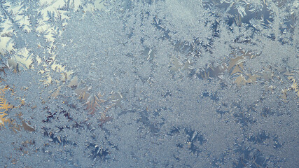 Ice and frost on the window pane in winter. A pattern of frozen water crystals, similar to the...