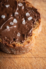 Slice of homemade bread with chocolate cream on the kitchen table for breakfast. Selective focus. Shallow depth of field.
