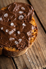 Slice of homemade bread with chocolate cream on the kitchen table for breakfast. Selective focus. Shallow depth of field.
