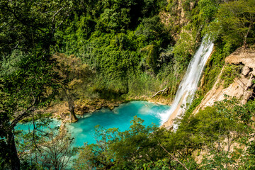toma superior de la cascada de Minas Viejas cayendo a un poza azul turquesa de agua dulce en la...