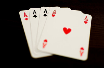 Aces poker on dark wood table