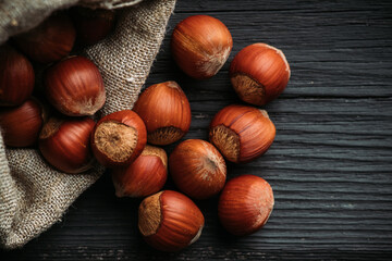 Hazelnuts in shell in pouch on the rustic background. Selective focus.