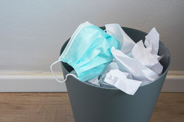 Used surgical face mask in a blue bin. The masks used during the Corona Covid-19 virus epidemic...