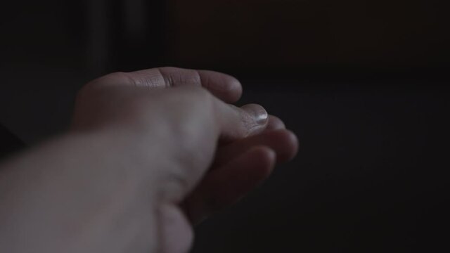 Slow motion closeup shot of man snap fingers in dim light
