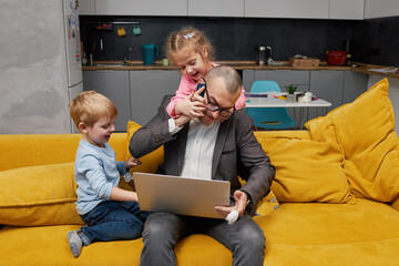 Father working from home with kids during quarantine and closed school. coronavirus outbreak. Young...