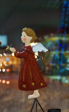 Angel figure in showcase  anf city lights at background