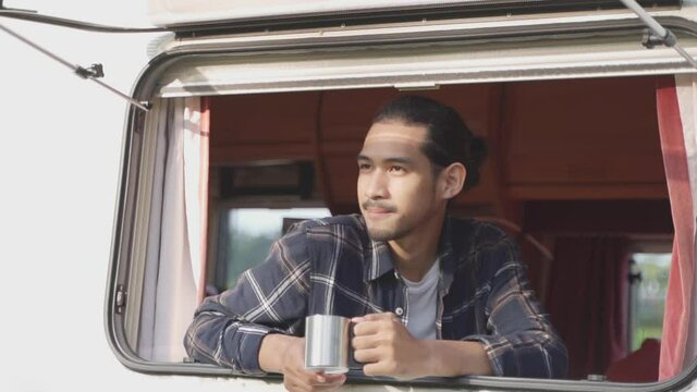 Smiling teenage traveler sit inside caravan seeing beautiful nature.