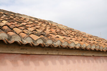 A Spanish-style roof made out of terracotta coloured tiles under a grey, cloudy sky in Malaga, Spain.  Image has copy space.
