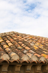 A Spanish-style roof made out of terracotta coloured tiles under a grey, cloudy sky in Malaga, Spain.  Image has copy space.