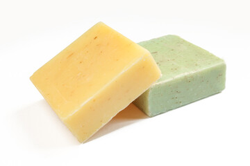 Two natural herbal soaps isolated on white background. Green and yellow square shaped products