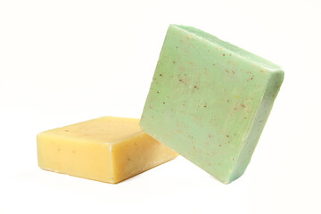Two natural herbal soaps isolated on white background. Green and yellow square shaped products