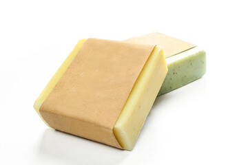 Two natural herbal soaps isolated on white background. Green and yellow aquare shaped products
