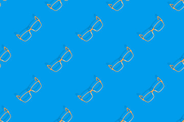 Background on the theme of glasses. Orange glasses seamless pattern on a blue background.