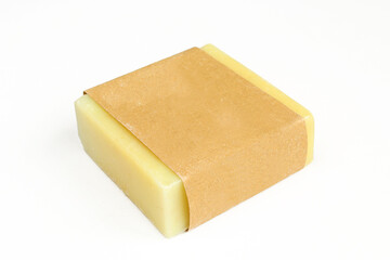 Yellow herbal soap isolated on white background. Homemade soap wrapped in blank paper