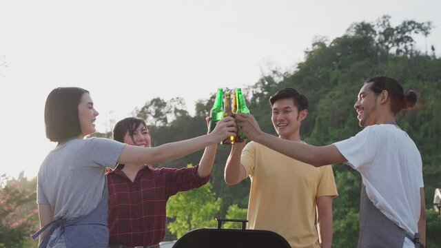 Friend clinking and drinking bottles of beer with happiness and smile.