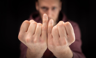 Hands of disabled man with different long pinkie finger shown into the camera