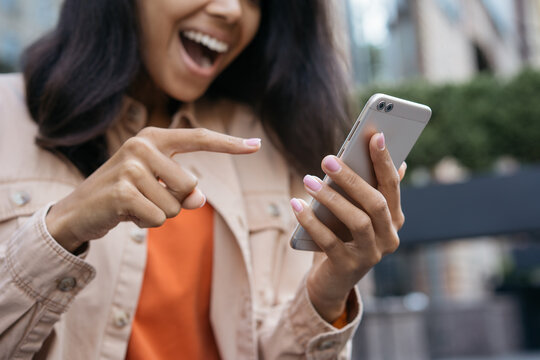 Close up portrait of happy emotional woman with wide open mouth using mobile app, shopping online, sport betting. Young smiling blogger influencer holding modern smartphone, communication online